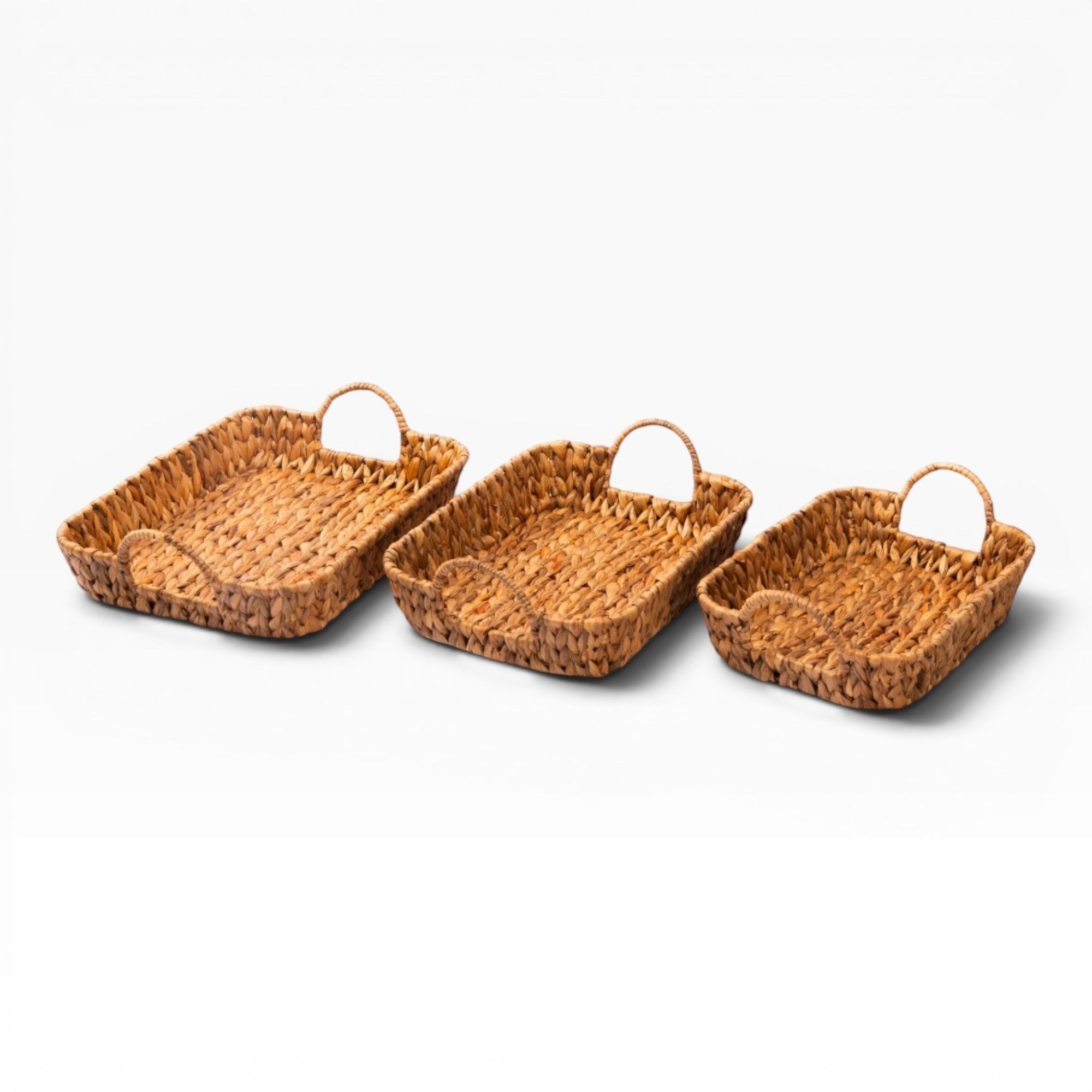 Home Basket set of three woven water hyacinth rectangular trays with handles, natural earthy tone, rustic charm.